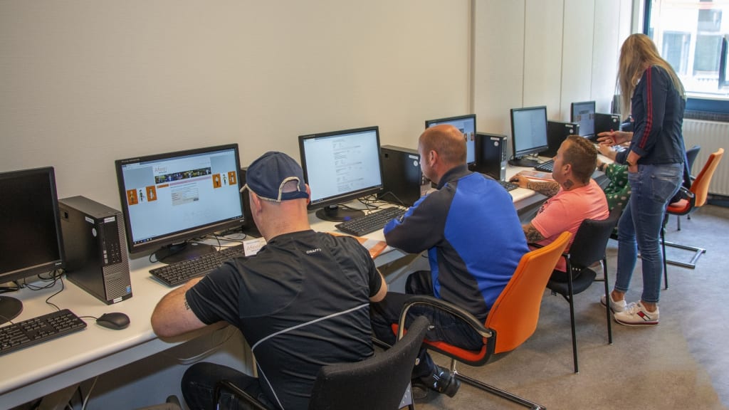 deelnemers aan een training zitten achter hun computer