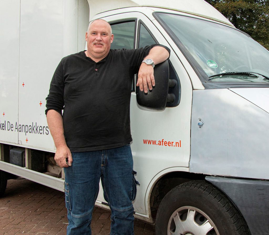 Abel Middel bij de vrachtwagen die hij net gerepareerd heeft