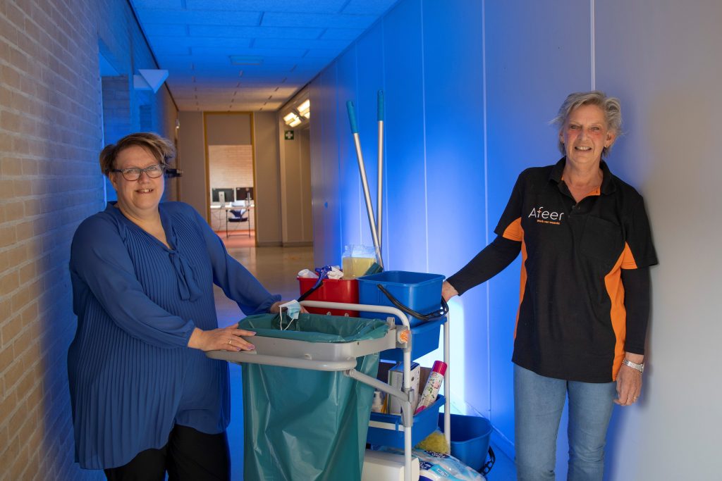 Monique en Ineke in het gebouw van de BRP-straat in Emmen met een schoonmaakkar tussen hen in