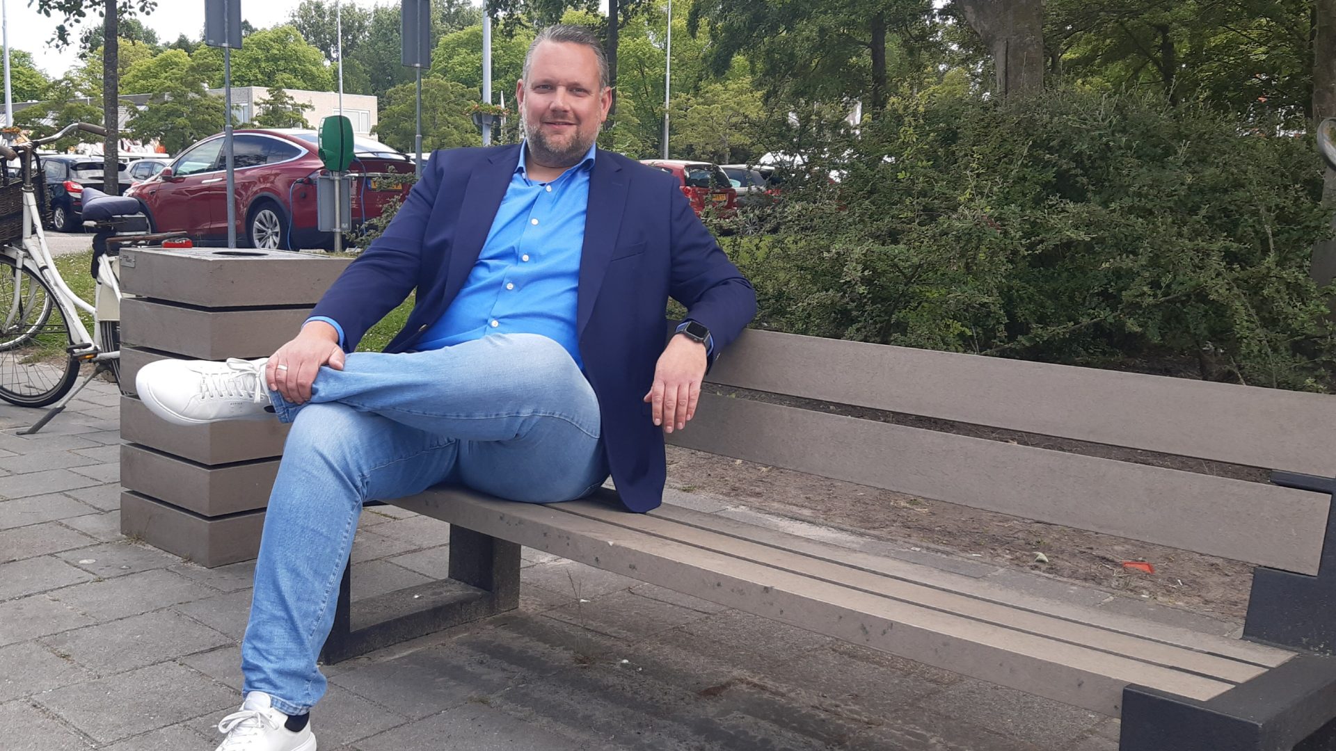 Niek Jansema zittend op een vanAfval-bankje buiten bij het winkelcentrum Paddepoel in Groningen