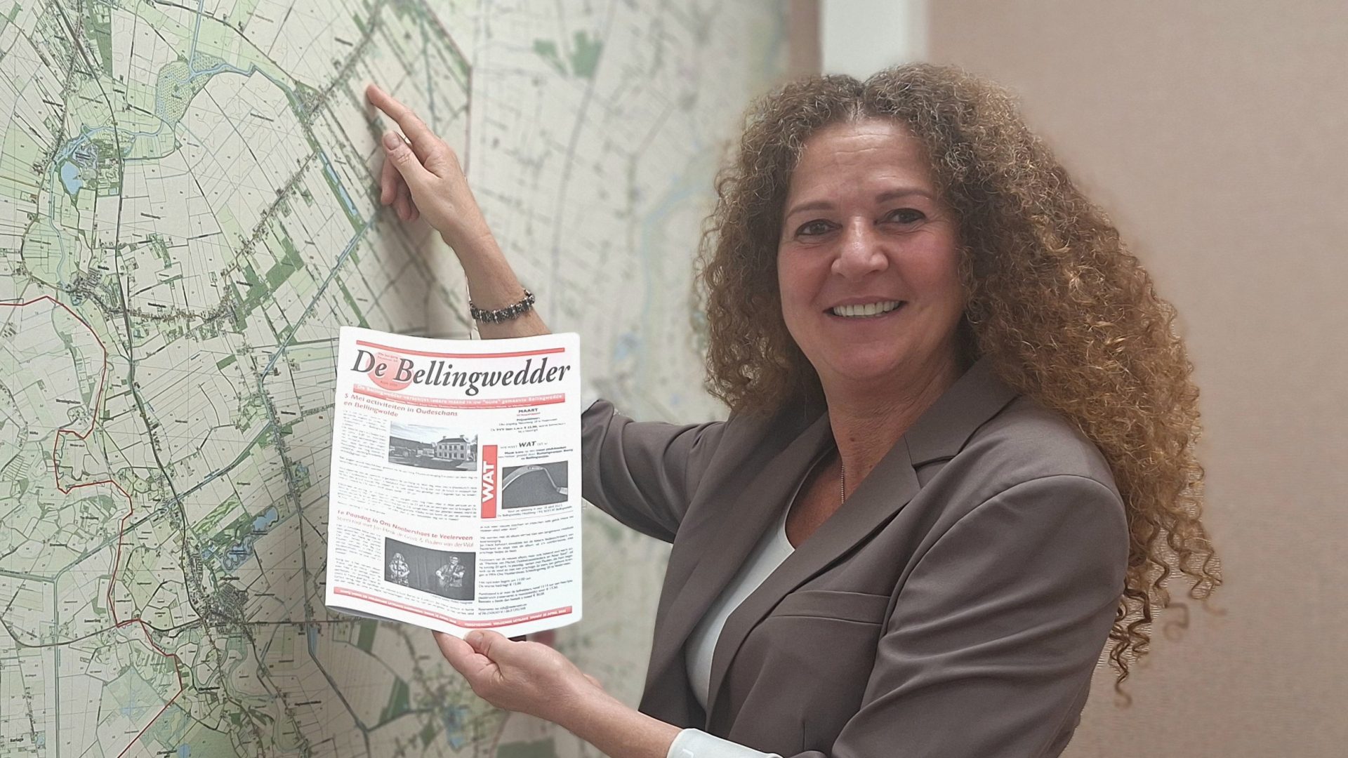 Fatima van den Broek staat bij een plattegrond en laat het gebied van de Bellingwedder zien