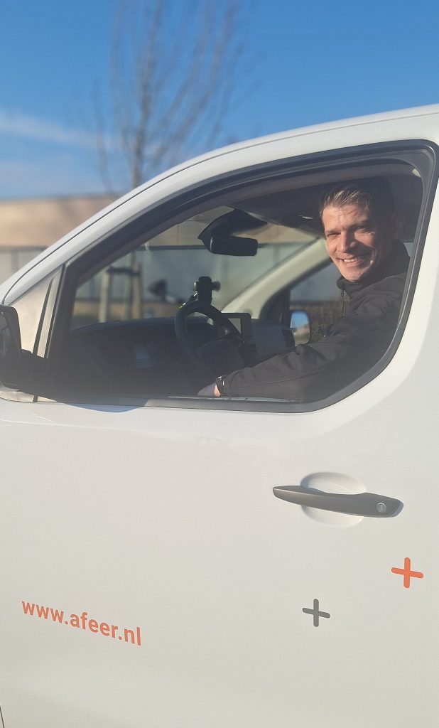 Jeroen achter het stuur van een busje van Afeer